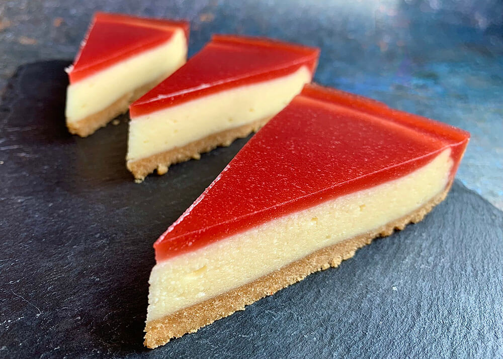 tri kúsky jahodového cheesecaku na bridlicovej tácke