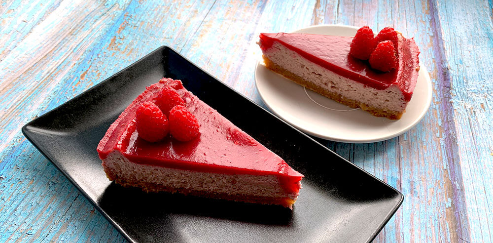 dva malinové cheesecaky na čiernom a bielom tanieriku