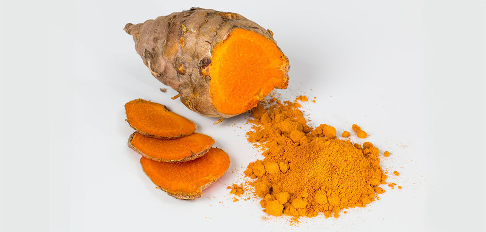 detail sušenej kurkumy a podzemku na bielom podklade