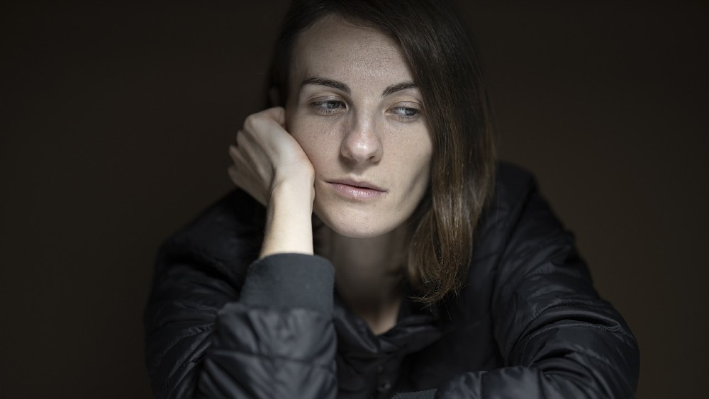 unavená a smutná žena opierajúca sa o ruku