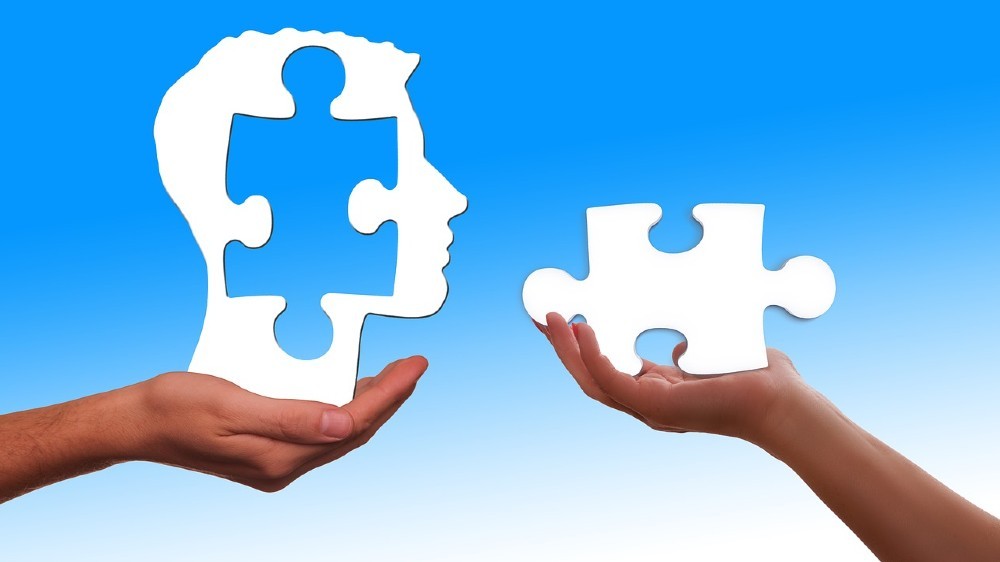ruky držiace puzzle a hlavu
